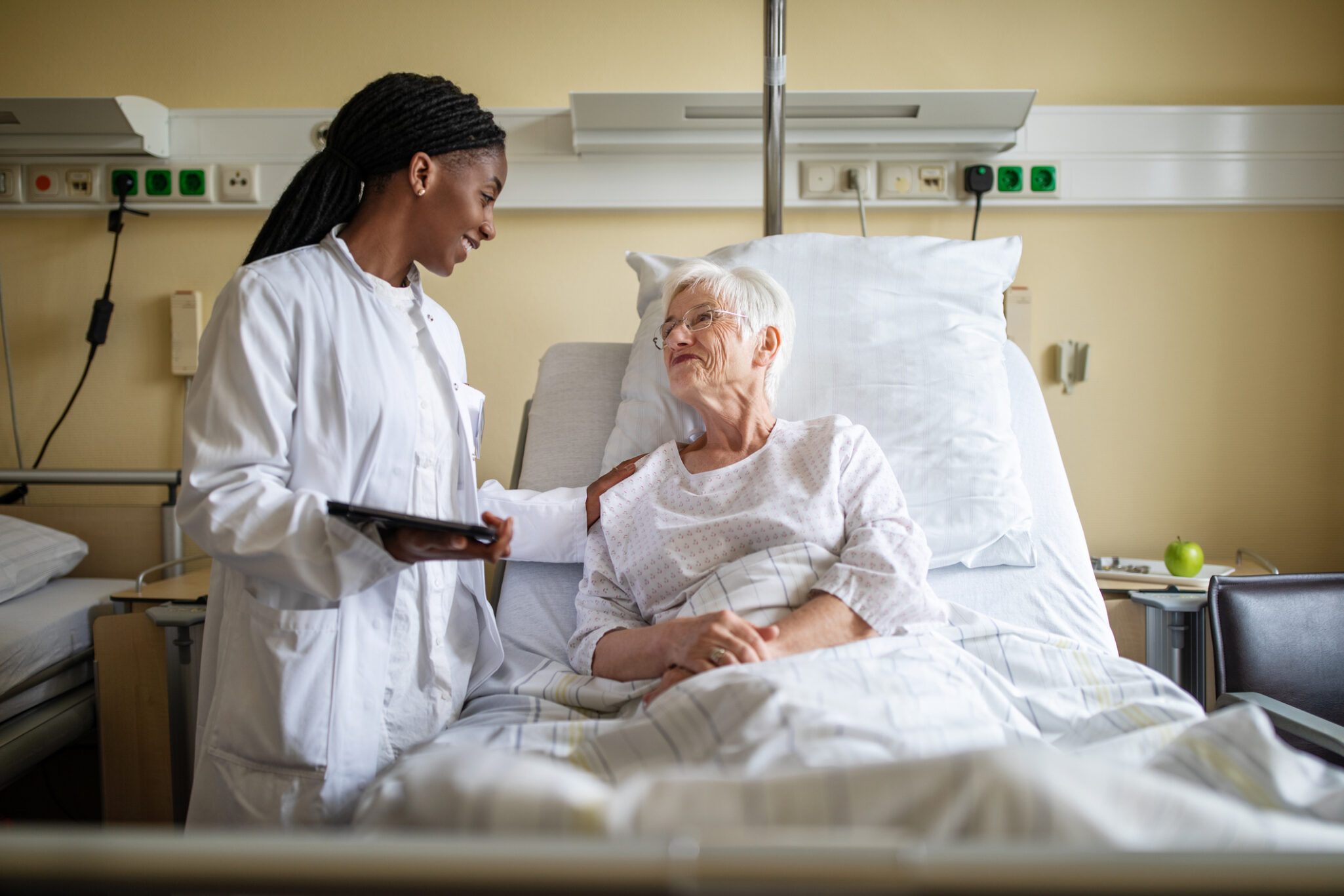 A doctor meets with an older adult who is receiving post hospital rehabilitation care