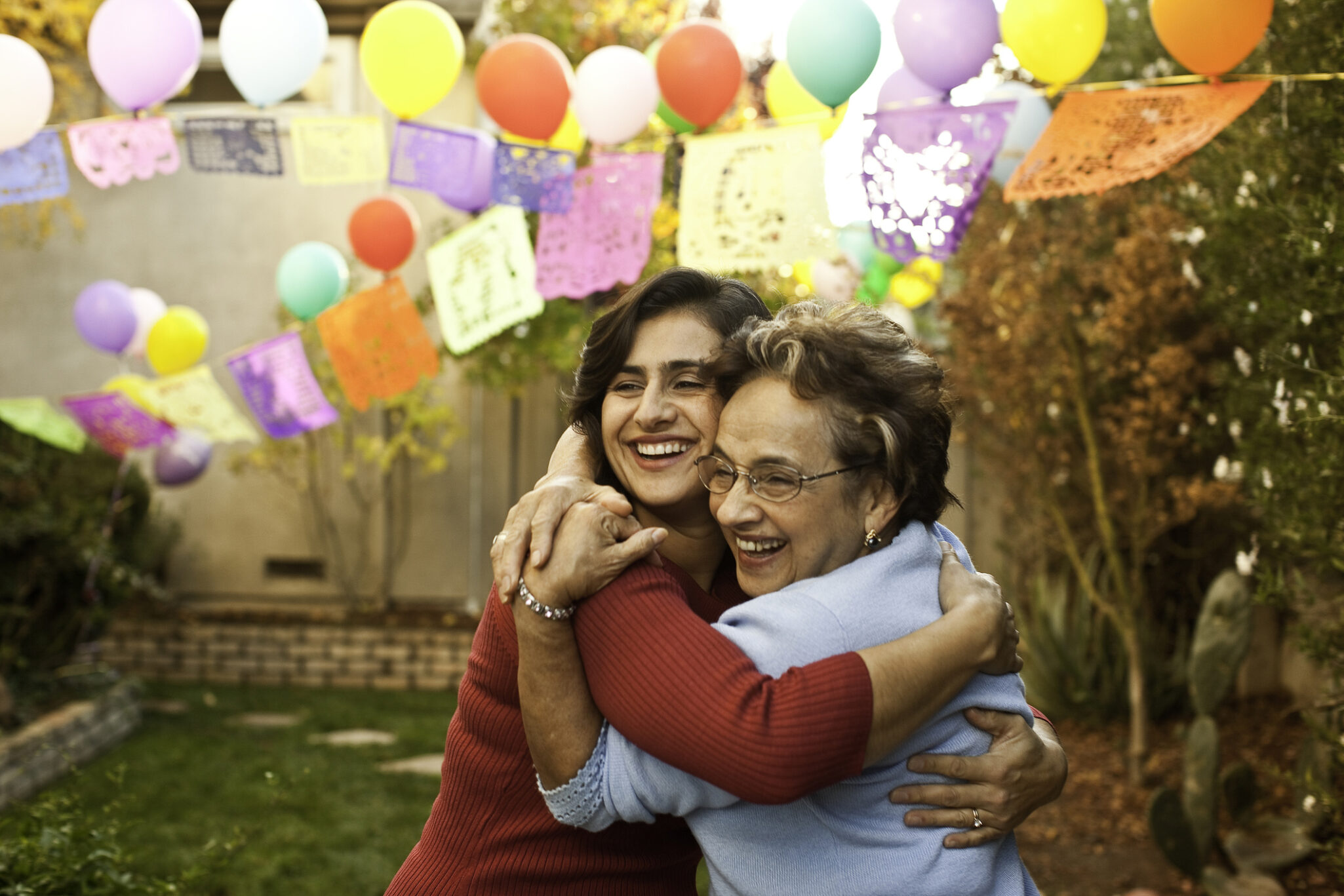 A grandmother and daughter hug at a family event