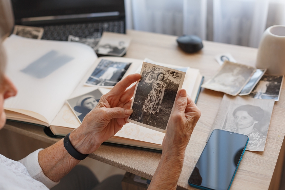 An older adult looks at photos in a photo album